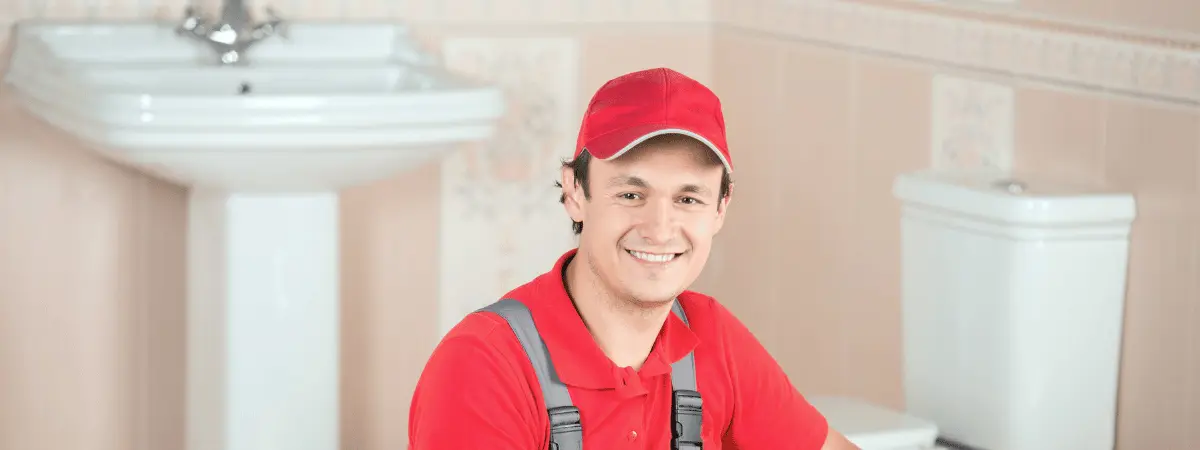 Licensed plumber repairing a residential water pipe under a sink