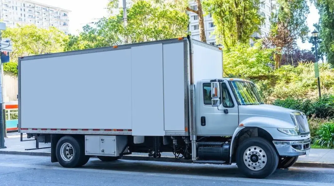 Junk removal truck being loaded with old furniture and debris